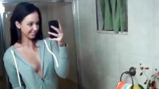 Wee angel flashing delightful whoppers and devouring lollipop near mirror